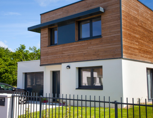 Extérieur maison neuve composée d'un jardin et d'une voiture ainsi que des fenêtres grises | Menuiseries Bouvet