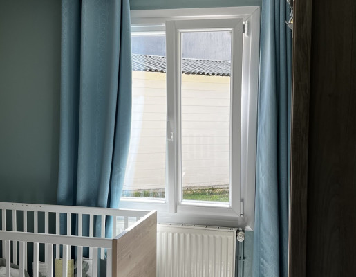 Intérieur chambre enfant rideaux bleus et fenêtre blanche | Menuiseries Bouvet