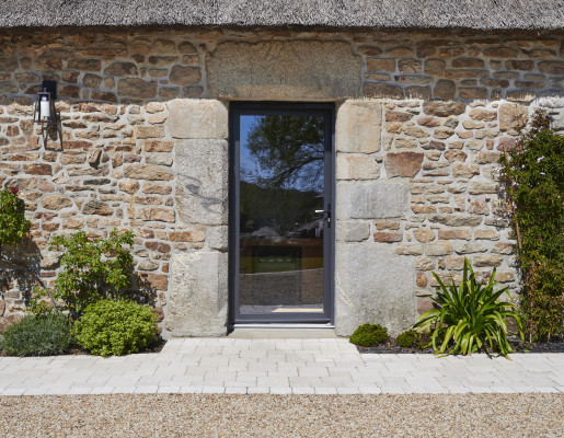 Maison en pierre avec une porte fenêtre gris anthracite | Menuiseries Bouvet
